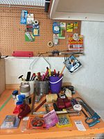 Overview of workbench with hand tools, tape gun, saws, bucket, tapes and packaged hardware