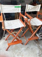 Front view of both tall wooden director chairs showing canvas seats/backs