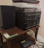Overall view of Panasonic component stack on table with left speaker and cables visible