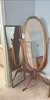 Cheval mirror and framed wall mirror standing together