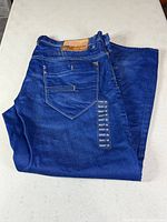 Folded jeans showing rear pocket, leather logo patch and overall color