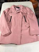 Front view of pink overcoat laid flat showing overall style and pockets