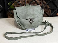 Front view showing flap, clasp, texture, strap