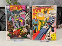 Both bagged comic books on clear stands