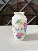 Front view of porcelain vase showing floral and figural design