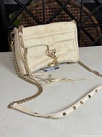 Front view of cream textured leather crossbody showing size, strap, hardware