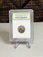 Front of INB-slabbed Roman coin on stand