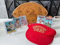 Overall lot showing visor, wood plaque and five trading cards on stands