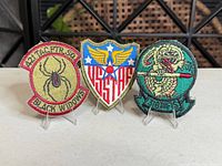 Group shot of all three embroidered patches standing on acrylic stands