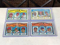 All four Topps cards in plastic holders on table surface