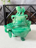 Full view showing lid, dragon handles, foo dog finial, tripod feet