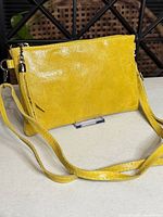 front of yellow leather crossbody with strap and tassel
