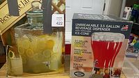Both sides of boxed 3.5-gallon beverage dispenser visible