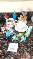 Group view of all figurines, mug, teacup and saucer