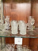 Lot overview showing tumblers, vases, single and double candlesticks