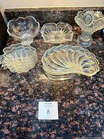 Group shot showing all glass pieces: shell dishes, square dishes, bowls, footed compote