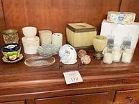 Entire assortment of candle holders, dishes, figurine and seashells displayed on shelf