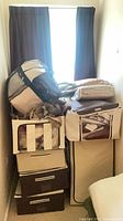 Stack of beige and brown storage bins, bedding bags, pillows