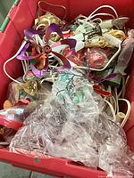 Overview of red bin containing assorted Christmas decorations and white electrical cords