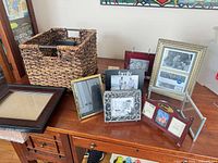 Basket and several frames displayed on table
