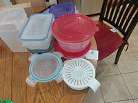 Assorted containers, lids and juicer spread on table