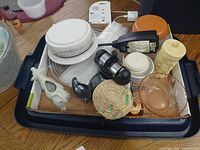 Top view of bin showing scale, cow creamer, bird figurine, straw coaster, charger, glass dishes