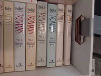 Shelf view showing Psalms, Romans and John volumes with dust jackets