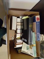 Top view of cardboard box with multiple Christian books stacked vertically