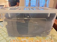 Clear plastic bin showing folded clothing inside