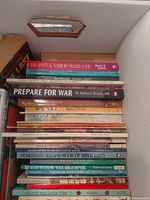 Stack of Christian books showing top titles The Spiritual Warrior's Prayer Guide and Prepare for War