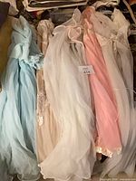 Four pastel chiffon nightgowns arranged side by side