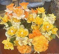 Footed crystal compote filled with mixed yellow and orange silk flowers