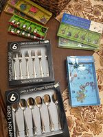 Two boxed Hampton Forge flatware sets and three boxed Art Glass wine charm sets