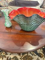 Large ruffled art glass bowl and small bud vase on table