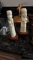 Two carved wooden vases on countertop