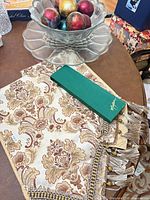 Glass bowl containing decorative spheres, table runner, knife box visible