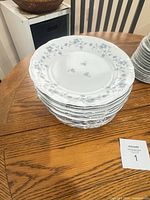 Stack of dinner plates showing floral pattern and silver trim