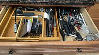 Drawer overview showing assorted utensils in wooden organizer