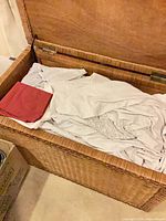 Chest open showing interior wicker lining and linens