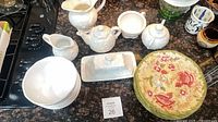 Group shot of all plates, bowls, and white embossed serving pieces