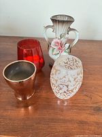 Group shot of all four decorative vessels on wooden surface