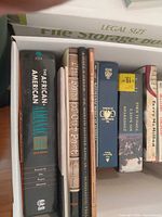 Box showing eight books with visible spines including African-American Almanac and Zondervan Bible