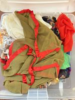 Plastic bin containing assorted scarves and wraps in multiple colours and fabrics