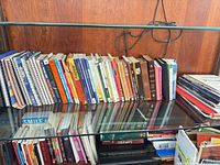 Top shelf showing spiral notebooks and row of books including Bibles
