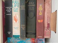 Front spines of seven upright hardcovers showing titles and condition