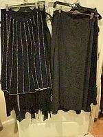 Front view black pinstripe skirt and black A-line skirt on hangers