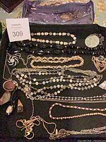Full lot view on black tray including pouch and multiple jewelry pieces