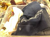 Top view of bin showing cream knit beaded top and blue jeans with chevron stitching