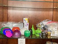 Full lot on shelf showing funnels, produce savers, Fresh Cube boxes, gloves pack and bag of small gadgets