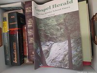 Overview showing Gospel Herald magazine and several Bibles